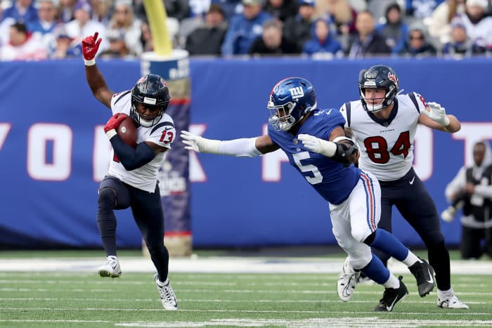 wide receiver Brandin Cooks runs with the ball as Kayvon Thibodeaux reaches for him